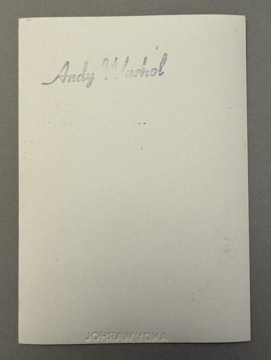 Andy WARHOL (1928-1987), Attribué à. Photographie argentique en noir et blanc, représentant Andy Warhol au déjeuner. Signé au marqueur. Tampon de la signature « Andy Warhol » au dos de la photographie. Timbre sec en creux Andy Warhol. – Image 2