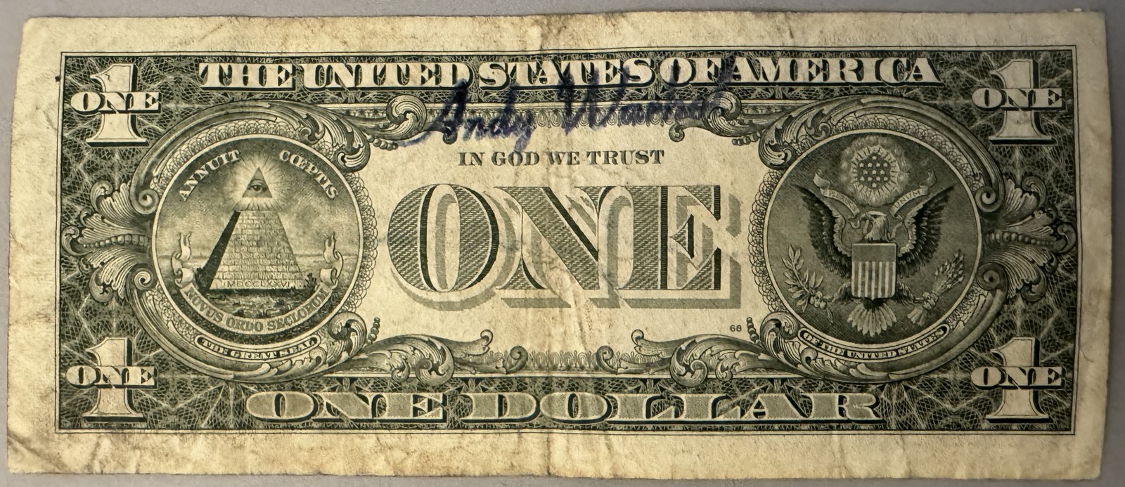 Andy WARHOL (1928-1987), Attribué à. Billet de 1 dollar Américain. Signé « Andy Warhol » au marqueur. Billet datant de 1985 et portant deux timbres de 20ct portant le cachet US Air Mail. Cachet de la signature au dos. Dimensions : 6,6 x 15,7 cm. - Image 2
