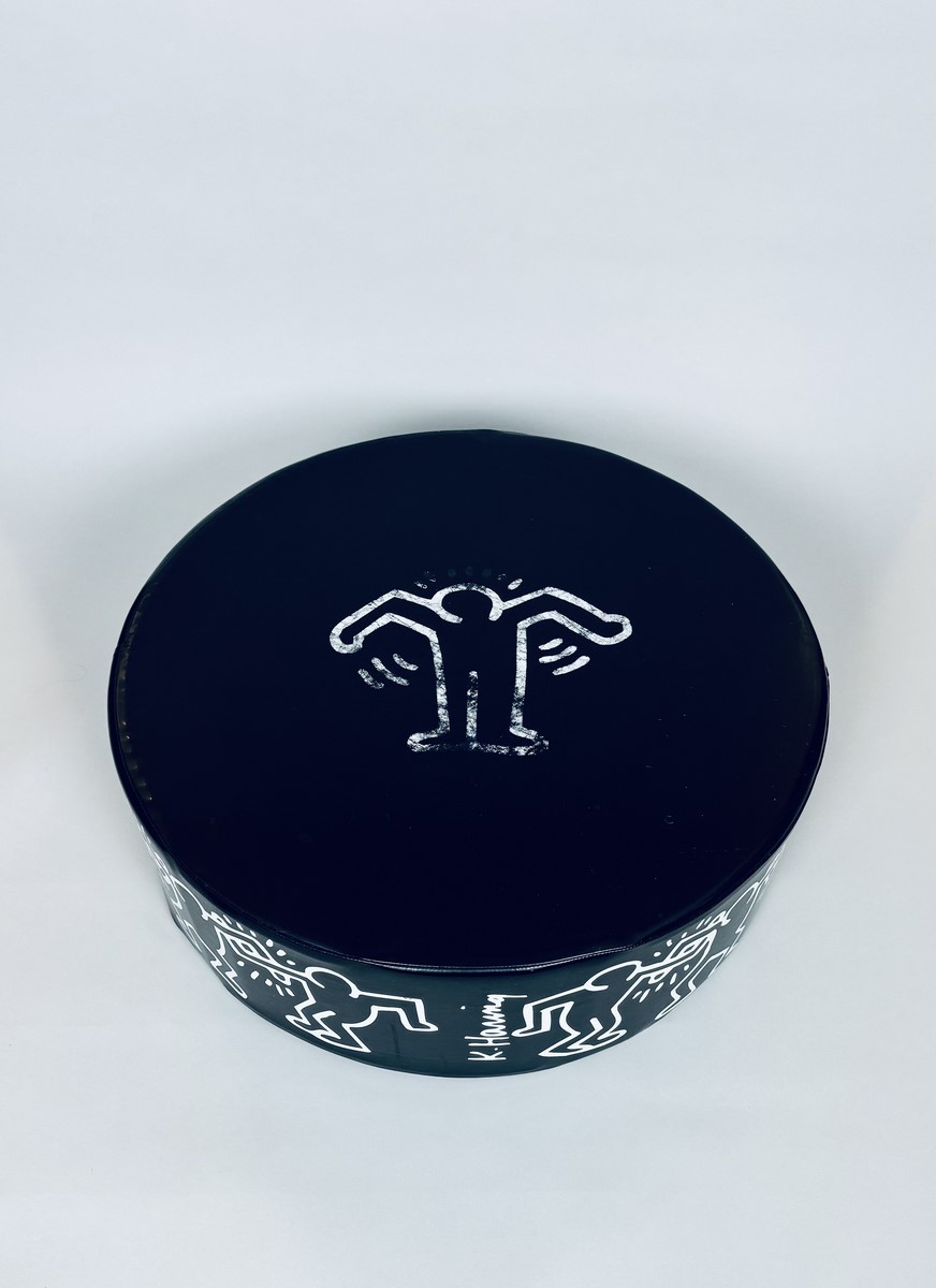 Keith HARING (1958-1990) Pouf circulaire en mousse gainée de skaï noir orné d'un personnage stylisé blanc