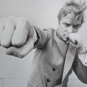 ANONYME - MICHAEL CAINE. Photographie de presse.  Epreuve en noir et blanc sur papier lambda