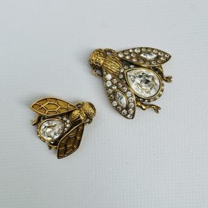 CHRISTIAN DIOR -Deux broches en métal doré et strass figurant une petite et une grande abeille. Signé.4,8 x 4,5 cm – 3,8 x 3,6 cm