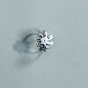 TRAVAIL DES ANNEES 70. BAGUE en platine à motif floral ornée d’un diamant central de 0,33 carat (environ).