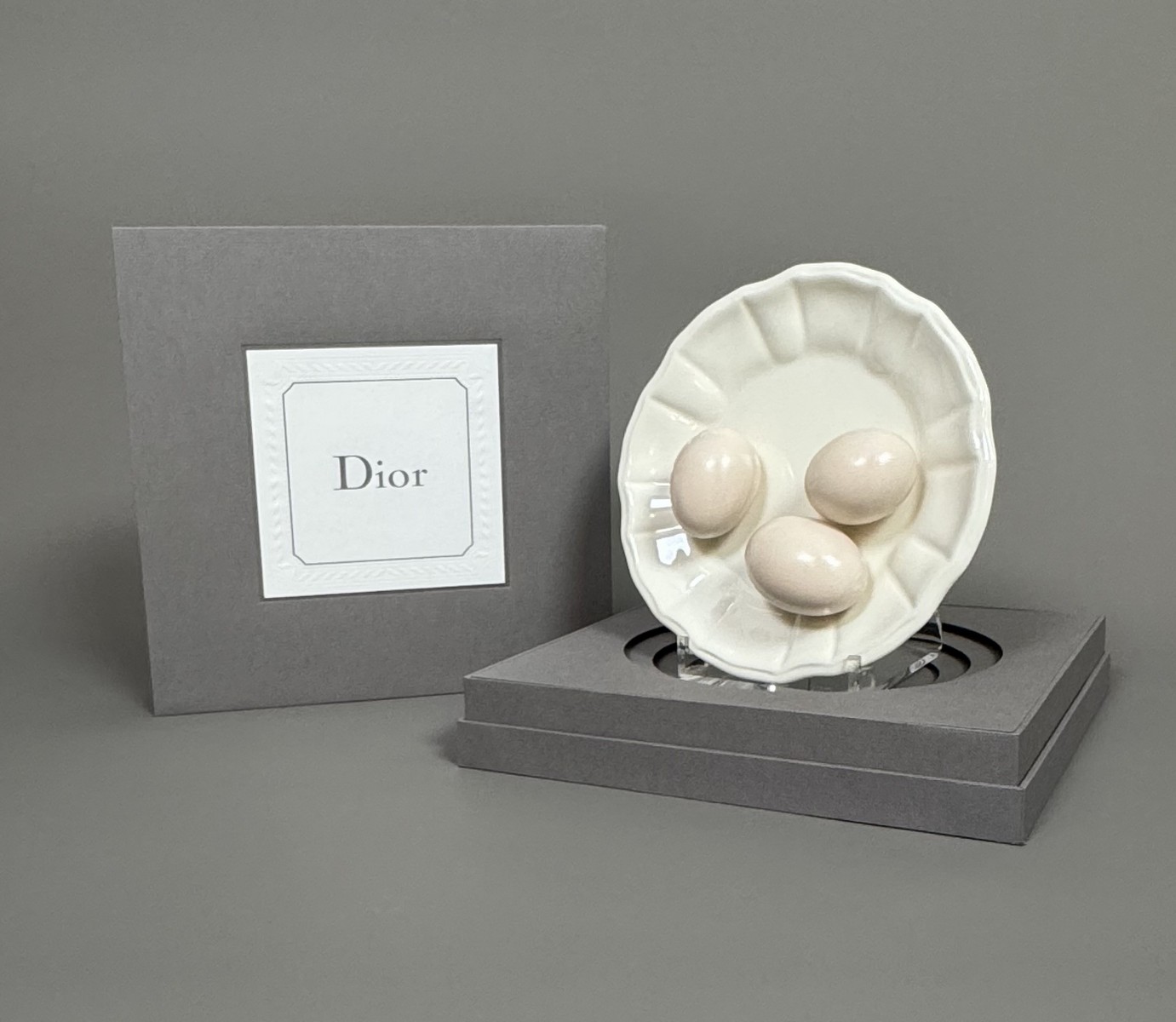DIOR. Assiette décorative en faïence écrue à motif 3 œufs en trompe-l’œil. – Image 2