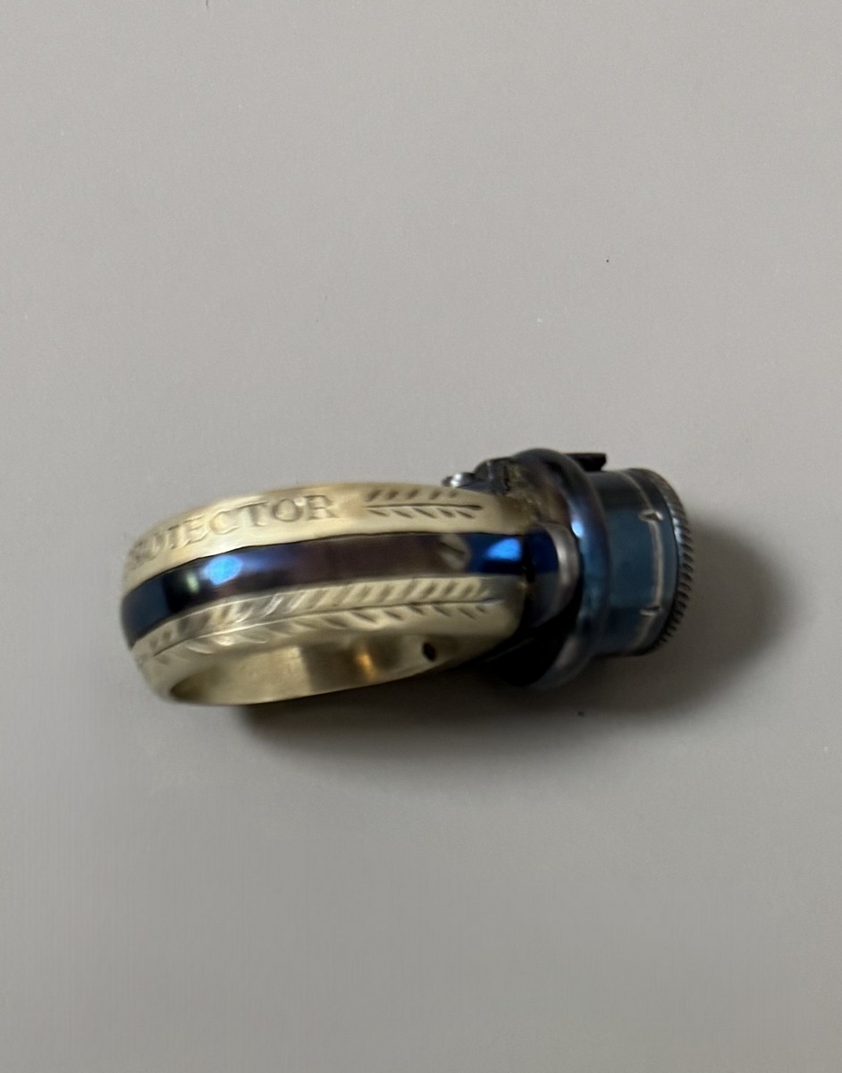 BAGUE RÉVOLVER, « le petit Protector », à broche, 6 coups, calibre 4 mm. Barillet bleu, guilloché sur le bord pour être tourné à la main. Détente latérale. Anneau en maillechort gravé de feuillages et marqué « LE PETIT PROTECTOR » XXe siècle. Dans son coffret en cuir décoré au petit fer, avec plaque en argent gravée « Le petit protector », garni à l’intérieur de velours. Avec sa boîte d’origine (6,7 x 8,2 , 2 cm) , 6 balles de plomb et un tournevis. Complet. - Image 5