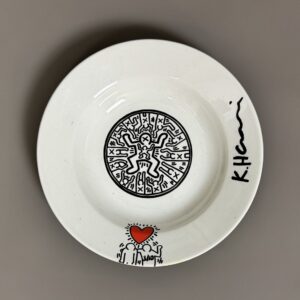 Keith HARING (1958-1990), Attribué à.   Dessin au marqueur sur une assiette creuse en céramique blanche sérigraphiée, porte une signature, numérotée 3/10 et le cachet ‘The Estate of Keith Haring » au dos.