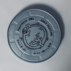 Keith HARING (1958-1990), Attribué à.  Boîte de film du "Montreux Jazz Festival 1983" portant un dessin au marqueur noir et une signature.