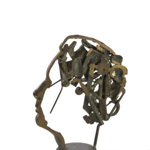 ARMAN (1928-2005)   « Prix de la mémoire de l’homme ». 1989. Accumulation de divers objets dans un profil de visage à l’antique, bronze soudé à patine brune, bord de coupe poli.