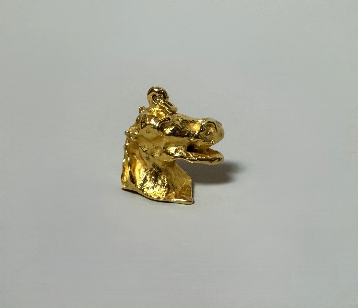 Salvador DALI (1904-1989) « Cabeza de Cabello riendo ». 1974. Pendentif tête de cheval riant en bronze doré à l’or fin. Signé « Dali » en creux en-dessous.
