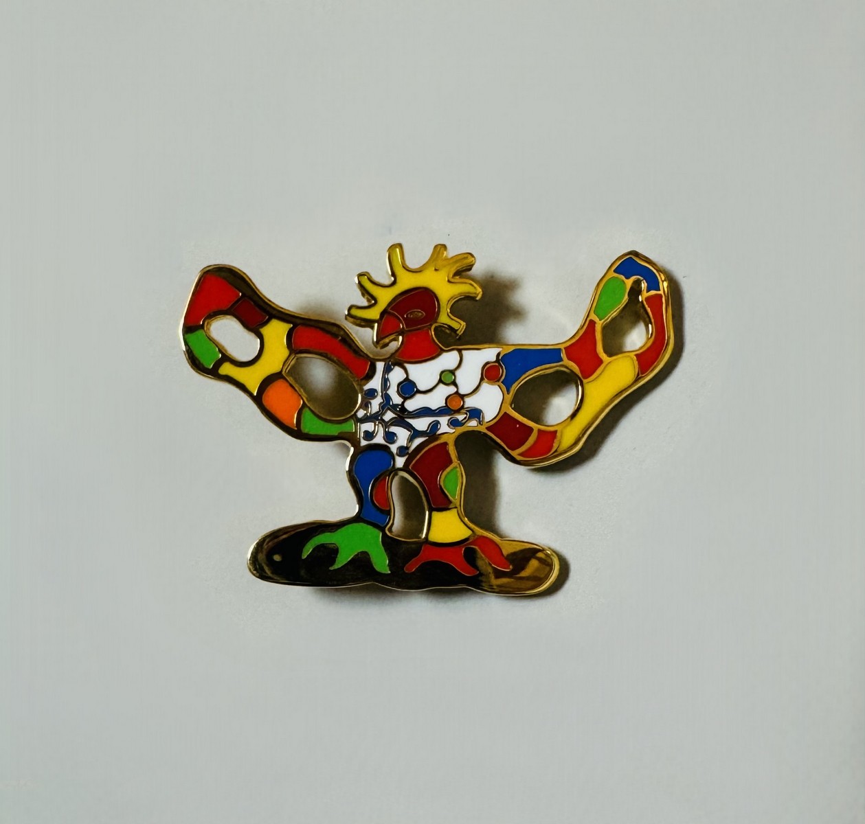 Niki de SAINT PHALLE (1930-2002) d’après. « Oiseau de feu » Broche-pendentif en métal doré et émail polychrome. Signée « Niki de Saint Phalle au dos ».