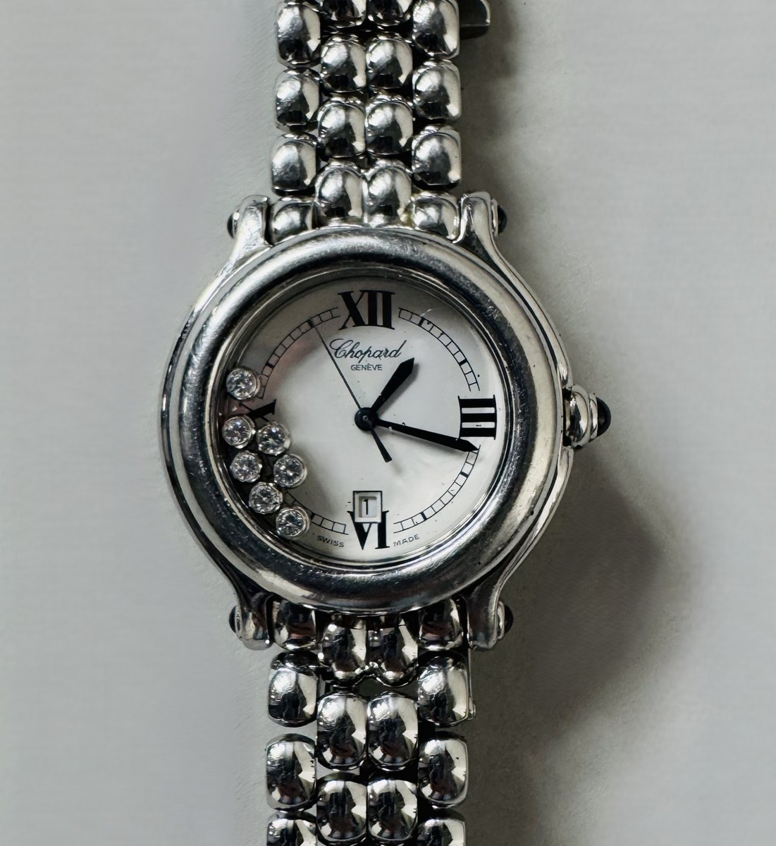Montre CHOPARD, modèle "Happy Sport", à mouvement quartz, boitier acier 26 mm, cadran blanc, chiffres romains et chemin de fer, 7 diamants mobiles (total de 0,15 ct environ).