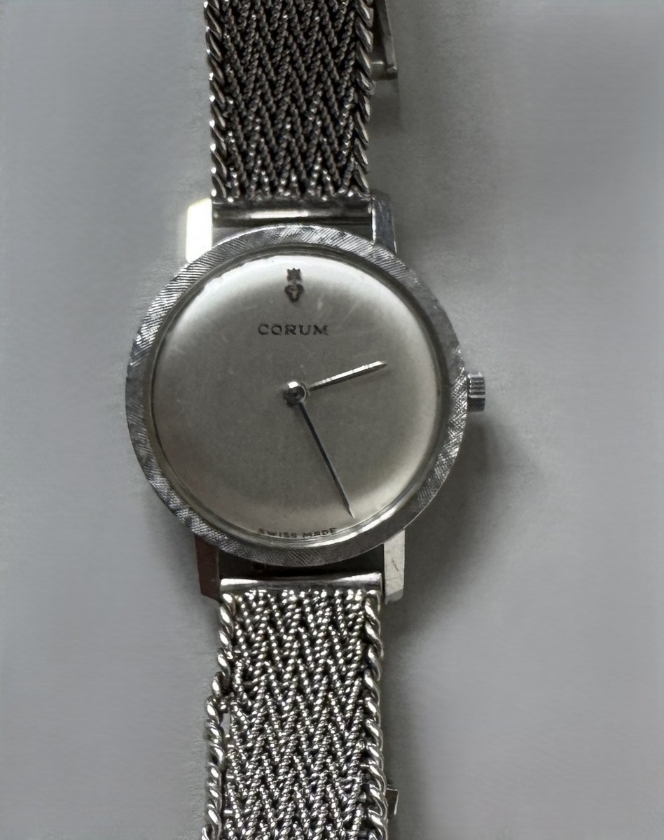 CORUM vers 1970, Montre bracelet en or gris, cadran argent, fond clippé. Aiguilles batons. Mouvement mécanique. Bracelet souple en or gris tressé. Poids brut : 38 gr.