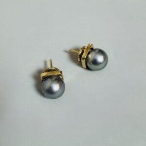 Paire de boucles d’oreilles clous en or jaune 18 carats 750 millièmes retenant chacune une perle noire dite de Tahiti, diamètre des perles : 9 mm environ.