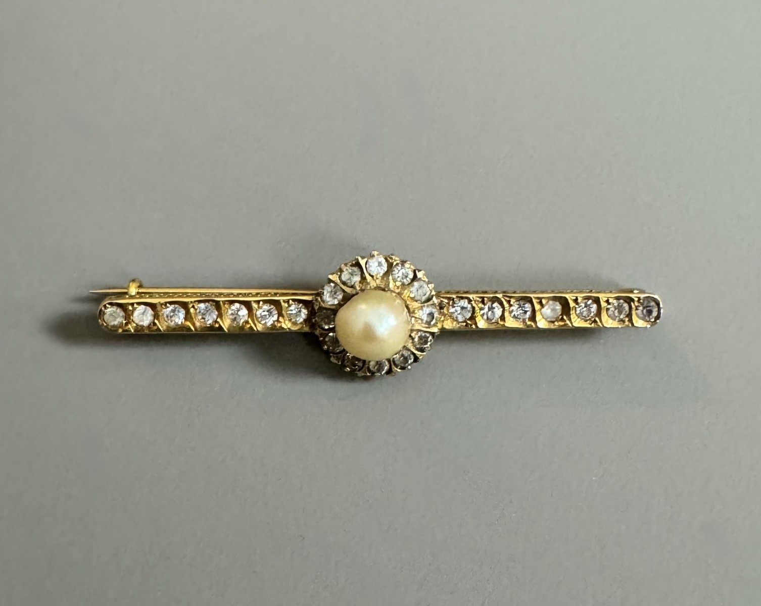TRAVAIL DU XIXème SIECLE - BROCHE barrette en or jaune 18k (750 millièmes) ornée sur la partie centrale d’une perle bouton et de diamants brillantés taille ancienne,