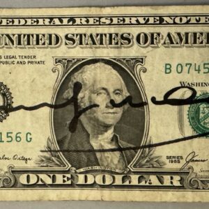Andy WARHOL (1928-1987), Attribué à. Billet de 1 dollar Américain. Signé « Andy Warhol » au marqueur. Billet datant de 1985 et portant deux timbres de 20ct portant le cachet US Air Mail. Cachet de la signature au dos.  Dimensions : 6,6 x 15,7 cm.