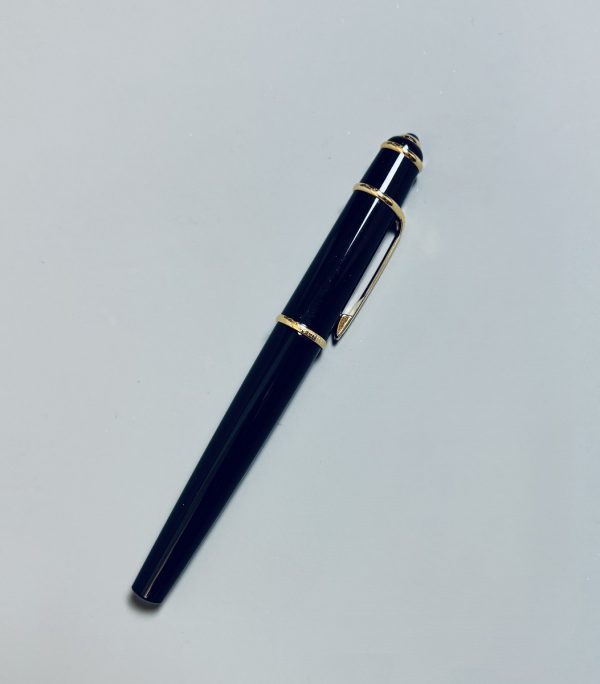 CARTIER.  Stylo Roller-Ball de la collection Diabolo, résine noire, attributs plaqués or.  Cabochon saphir au sommet du capuchon. Signé. Dans son coffret d’origine. Poids brut : 39 gr. – Image 2