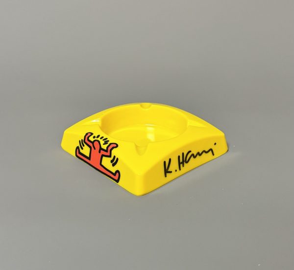 Keith HARING (1958-1990), D’Après.  Cendrier en plastique jaune. Signé au marqueur.